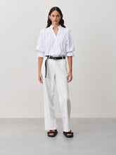 Load image into Gallery viewer, Witte Blouse van de Jane Lushka Collectie. Olivia Blouse is een vrouwelijke blouse met knoopjes, heeft een V-hals met ruffles aan de kraag en plooitjes op het voor en achterpand, als mooi detail. Met een gepofte 3/4 mouw en elastiek smokwerk. Blouse Olivia heeft een chique uitstraling en staat voor vrouwelijkheid en elegantie. De blouse is uitgevoerd in het wit, lila en armygreen en is van de bekende travel kwaliteit.