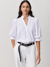 Load image into Gallery viewer, Witte Blouse van de Jane Lushka Collectie. Olivia Blouse is een vrouwelijke blouse met knoopjes, heeft een V-hals met ruffles aan de kraag en plooitjes op het voor en achterpand, als mooi detail. Met een gepofte 3/4 mouw en elastiek smokwerk. Blouse Olivia heeft een chique uitstraling en staat voor vrouwelijkheid en elegantie. De blouse is uitgevoerd in het wit, lila en armygreen en is van de bekende travel kwaliteit.