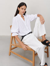 Load image into Gallery viewer, Witte Blouse van de Jane Lushka Collectie. Olivia Blouse is een vrouwelijke blouse met knoopjes, heeft een V-hals met ruffles aan de kraag en plooitjes op het voor en achterpand, als mooi detail. Met een gepofte 3/4 mouw en elastiek smokwerk. Blouse Olivia heeft een chique uitstraling en staat voor vrouwelijkheid en elegantie. De blouse is uitgevoerd in het wit, lila en armygreen en is van de bekende travel kwaliteit.