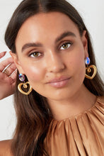 Afbeelding in Gallery-weergave laden, Gouden oorbellen met glaskraal en bedel in de vorm van een hart. De oorbellen zijn mega trendy en zijn perfect te combineren met meerdere gouden sieraden. De oorbellen zijn gemaakt van Stainless steel in combinatie met glaskralen en hebben een afmeting van 4,98 cm. Wauw! Wat een prachtige statement oorbellen.