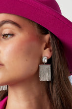 Afbeelding in Gallery-weergave laden, Goudkleurige Oorbellen met hangende slingers van steentjes in de kleur goud. Daarnaast zijn deze prachtige statement oorbellen voorzien van een grote steen, superleuk toch. Erg leuk om deze oorbellen te combineren met meerdere sieraden met glitter details. Afmeting oorbellen is 5.3cm x 2.60cm.