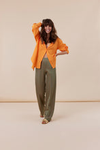 Afbeelding in Gallery-weergave laden, Groene Broek, Corel Broek Lily Wide Jaquard Circle heeft een subtiele glans in de kleurencombinatie groen en oranje. Een broek met rechte losvallende pijpen en paspelzakken op de achterkant en groene knoopjes. Het patroon geeft een chique maar eigentijdse uitstraling. Een broek met dé perfecte en zeer mooie vrouwelijke pasvorm.