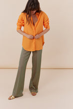 Afbeelding in Gallery-weergave laden, Corel Broek Lily Wide Jaquard Circle heeft een subtiele glans in de kleurencombinatie groen en oranje. Een broek met rechte losvallende pijpen en paspelzakken op de achterkant en groene knoopjes. Het patroon geeft een chique maar eigentijdse uitstraling. Een broek met dé perfecte en zeer mooie vrouwelijke pasvorm.