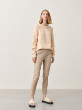 Afbeelding in Gallery-weergave laden, Zandkleurige Broek van Jane Lushka, Doris Pants van de travel kwaliteit zit uiterst comfortabel, een slim fit broek met veel stretch. Deze broek heeft een elastische band, grote zakken op de voorkant, een prachtig design, waardoor de broek een combi is van minimalistisch cargo en chic casual. Op de achterkant heeft de broek zakken met knoopjes.