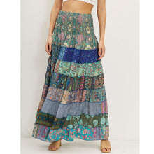 Afbeelding in Gallery-weergave laden, Maxi Rok Patchwork Blue is een prachtige wijde zomerrok met print in verschillende kleuren blauw. De rok heeft verschillende stroken en een gesmokte elastieken tailleband. Elke rok heeft een UNIEKE print, deze kan afwijken van de afbeelding. Stuk voor stuk een plaatje.