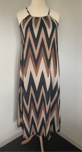 Load image into Gallery viewer, Jurk Maxi Viscose V Patroon is een lange jurk van viscose, in aardetinten met lurex. Jurk heeft veel stretch en zit heerlijk, heeft een ronde hals met elastiek en spaghettibandjes.
De jurk is one size en is te dragen van maat 36 t/m maat 44.