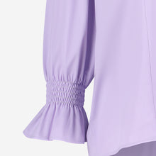 Load image into Gallery viewer, Paarse Blouse, Olivia Blouse Lila U724229 van de Jane Lushka Collectie is een vrouwelijke blouse met knoopjes, heeft een V-hals met ruffles en plooitjes op het voor en achterpand, als mooi detail. Met een gepofte 3/4 mouw en elastiek smokwerk.