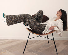 Load image into Gallery viewer, Broek van Corel, Lily Wide Peacock met oog voor detail, een jacquard gebreide peacock dessin in warme tinten. Wijde broek met dé perfecte en zeer mooie vrouwelijke pasvorm. In deze broek heeft namelijk écht iedereen mooie billen. Deze broeken zijn ideaal voor de langere dames, maar zijn ook gemakkelijk korter te maken.