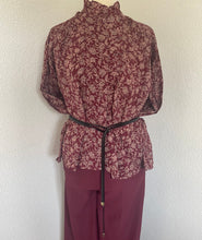 Load image into Gallery viewer, Wijnrode Blouse van Moment Amsterdam met referentie 57.100-23, is een prachtige romantische blouse met bloemenprint. Deze blouse heeft een opstaande kraag met ruffles aan de hals en mouwen. Deze blouse is mooi te combineren met de Corel Broek Lily Wide Uni Sport Beetroot.
