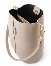 Load image into Gallery viewer, Stijlvolle en tijdloze bucket bag in een elegante beige tint, perfect voor dagelijks gebruik. Deze tas is vervaardigd van hoogwaardig, soepel leer met een subtiele structuur, wat zorgt voor een luxe uitstraling en een duurzame kwaliteit.