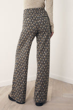 Load image into Gallery viewer, Wijde Broek van Corel, Lily Wide Peacock met oog voor detail, een jacquard gebreide peacock dessin in warme tinten. Broek met dé perfecte en zeer mooie vrouwelijke pasvorm. In deze broek heeft namelijk écht iedereen mooie billen. Deze broeken zijn ideaal voor de langere dames, maar zijn ook gemakkelijk korter te maken.