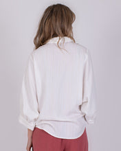 Load image into Gallery viewer, Offwhite Blouse Busan is een stijlvolle en verfijnde blouse uit de The Clothed Collectie. De subtiel verweven strepen geven de blouse extra structuur en zorgen voor een luxueuze uitstraling. De zachte offwhite kleur maakt dit item tijdloos en eenvoudig te combineren met zowel casual als meer geklede outfits. De blouse heeft een wijdere pasvorm die comfortabel draagt en mooi valt. De elegante 3/4 vlindermouwen geven het ontwerp een speels en vrouwelijk karakter.