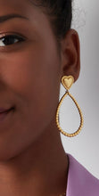 Load image into Gallery viewer, Goudkleurige Oorbellen in de vorm van een druppel met leuk hart detail. Erg leuk voor zowel een casual als feestelijke outfit. Ook erg leuk om deze oorbellen te combineren met meerdere sieraden met hartjes. De oorbellen zijn gemaakt van stainless steel en hebben een afmeting van 6,6 cm.