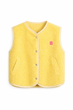 Load image into Gallery viewer, Lichtgeel Gilet van Teddystof met knopen en roze hart embleem. Dit comfortabele gilet met steekzakken is gemaakt van zachte teddystof en sluit met knopen. Het is afgewerkt met een bies en is voorzien van een trendy embleem op de voorkant.