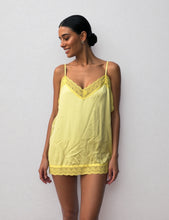 Load image into Gallery viewer, Deze gele elegante zijden Slip On Top straalt luxe en vrouwelijkheid uit. De top is afgewerkt met verfijnd kant aan zowel de boven- als onderzijde, wat zorgt voor een romantische en stijlvolle uitstraling. Dankzij de verstelbare spaghettibandjes kun je de top perfect naar wens aanpassen voor een comfortabele pasvorm.