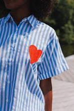 Afbeelding in Gallery-weergave laden, Gestreepte Blouse Now or Never Wit is een zomerse blouse van 100% katoen met korte mouwen en kraag. De voorkant van deze blouse heeft een rood hart en de achterkant is voorzien van een kleurrijke opdruk 'Now or Never'.
