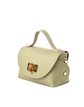 Load image into Gallery viewer, Stijlvolle en trendy mini tas met hengsel in een elegante groene tint, perfect voor dagelijks gebruik. Deze handtas is vervaardigd van hoogwaardig, soepel leer met een subtiele structuur, wat zorgt voor een luxe uitstraling en een duurzame kwaliteit. Het hoofdvak sluit met een praktische bamboe draaisluiting en biedt voldoende plek voor al je essentials.
De lange ketting maakt het mogelijk om de tas comfortabel over de schouder of crossbody te dragen.