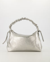 Afbeelding in Gallery-weergave laden, Lederen handtas van sauvage leer met een gerimpeld lederen handvat als mooi detail. Tas Raina is in een metallic uitvoering. De tas heeft een hoofdvak met ritssluiting en aan de binnenzijde een ritsvakje. Tas Raina is verkrijgbaar in verschillende kleuren: Metallic Zwart, Metallic Zilver met afmeting 28cm x 17cm x 8cm.