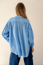 Load image into Gallery viewer, Blauwe Blouse Jasmin van de Moment Amsterdam Collectie is een wijde translucent blouse met een ronde hals, lange mouwen met plooitjes en bedekte knoopjes. Deze moderne blouse is een klokkend model met plooitjes. Een fijne blouse die je heerlijk door kunt dragen.
