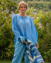 Load image into Gallery viewer, Blauwe Blouse Jasmin van de Moment Amsterdam Collectie is een wijde translucent blouse met een ronde hals, lange mouwen met plooitjes en bedekte knoopjes. Deze moderne blouse is een klokkend model met plooitjes. Een fijne blouse die je heerlijk door kunt dragen.