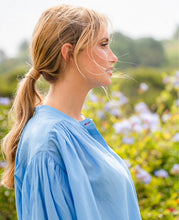 Load image into Gallery viewer, Blauwe Blouse Jasmin van de Moment Amsterdam Collectie is een wijde translucent blouse met een ronde hals, lange mouwen met plooitjes en bedekte knoopjes. Deze moderne blouse is een klokkend model met plooitjes. Een fijne blouse die je heerlijk door kunt dragen.
