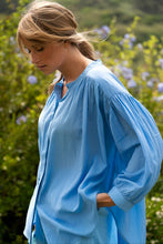 Load image into Gallery viewer, Blauwe Blouse Jasmin van de Moment Amsterdam Collectie is een wijde translucent blouse met een ronde hals, lange mouwen met plooitjes en bedekte knoopjes. Deze moderne blouse is een klokkend model met plooitjes. Een fijne blouse die je heerlijk door kunt dragen.