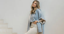 Afbeelding in Gallery-weergave laden, Deze poncho van Cycleur de Luxe biedt zowel stijl als sportiviteit. Deze poncho heeft lichtblauw als basiskleur met grijze accenten en is vervaardigd van een luxe mix. Met een eigentijdse capuchon en boeiende kleurvlakken aan de binnenkant zet poncho LAURA de trend. Deze cape poncho zorgt voor ongeëvenaard comfort en een lange levensduur en toont de kunst van de mondiale mode. Ontdek de perfecte aanvulling op jouw garderobe, is perfect te combineren met de prachtige LENA trui.