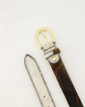Load image into Gallery viewer, Riem Balou is gemaakt van 100% Italiaans leer en heeft een trendy koeienvacht met een goudkleurige gesp. De riem is gemakkelijk korter te maken door middel van een schroef. Let wel! Het patroon op de riem kan afwijken van de afbeelding, gezien elke riem uniek is.