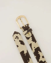 Afbeelding in Gallery-weergave laden, Cow Riem Evie is gemaakt van 100% Italiaans leer en heeft een trendy koeienprint en een goudkleurige gesp. De riem is gemakkelijk korter te maken door middel van een schroef.