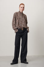 Load image into Gallery viewer, Jane Lushka Blouse Roberta is een verfijnde elegante maar een beetje speels blouse door de panterprint uit de collectie van Jane Lushka. Blouse heeft ruffles aan de voorkant, een hoge kraag, lange mouwen met elastiek en ruffles en heeft bruine knoopjes. Deze stijlvolle blouse is gewaagd en voor de zelfbewuste vrouw.