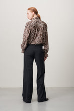 Load image into Gallery viewer, Jane Lushka Blouse Roberta is een verfijnde elegante maar een beetje speels blouse door de panterprint uit de collectie van Jane Lushka. Blouse heeft ruffles aan de voorkant, een hoge kraag, lange mouwen met elastiek en ruffles en heeft bruine knoopjes. Deze stijlvolle blouse is gewaagd en voor de zelfbewuste vrouw.