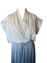 Load image into Gallery viewer, Witte Top Cecilia van de Moment Amsterdam Collectie is een top met een V-hals en een kapmouw. Deze katoenen blouse top heeft subtiele plooitjes en valt ruim.
Blouse Top Cecilia is verkrijgbaar in verschillende kleuren: wit, fuchsia (red).