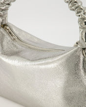 Afbeelding in Gallery-weergave laden, Lederen handtas van sauvage leer met een gerimpeld lederen handvat als mooi detail. Tas Raina is in een metallic uitvoering. De tas heeft een hoofdvak met ritssluiting en aan de binnenzijde een ritsvakje. Tas Raina is verkrijgbaar in verschillende kleuren: Metallic Zwart, Metallic Zilver met afmeting 28cm x 17cm x 8cm.