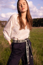 Load image into Gallery viewer, Ecru Blouse van Dame Blanche. Blouse Ajour A13 Aina Ecru is een prachtige blouse met ronde kraag en een strikje. De blouse heeft een ajour structuur met kleine geborduurde madeliefjes, 3/4 mouwen met elastiek aan de manchetten, waardoor het een subtiel pofmouwtje heeft. Deze blouse heeft een speelse uitstraling.