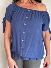 Afbeelding in Gallery-weergave laden, Blauwe Top Dobby heeft een kort mouwtje met een strikje, wat een leuk detail is. De top heeft een ronde hals, een rij knoopjes en heeft aan de onderzijde een elastische band met ruffles. Top kan zowel op de schouder als off-shoulder gedragen worden en is verkrijgbaar in verschillende kleuren. Kleur : Blauw, Geel, Wit