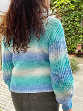 Afbeelding in Gallery-weergave laden, Trui Rain Turquoise/kobalt is een trendy grof gebreide trui met lange pofmouwen, een opstaande kraag en heeft een kabelpatroon op het voorpand. De trui is gemaakt van multicolor garen en is verkrijgbaar in één maat, draagbaar voor maat S/M/L en is verkrijgbaar in verschillende kleuren: Turquoise/kobalt, Roze/geel.