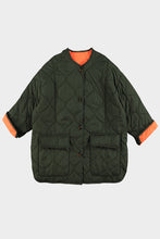 Load image into Gallery viewer, Groene Jas Doorgestikt is oversized, heeft lange mouwen, twee klep zakken en knopen om de jas te sluiten. Deze jas heeft twee contrasterende kleuren, binnenkant jas is fluo en de mouwen kunnen naar wens omgeslagen worden zodat de felle kleur als mooi accent zichtbaar wordt. Deze doorgestikte jas is verkrijgbaar in verschillende kleuren: groen/oranje, khaki/roze, bruin/geel.