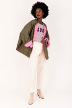 Load image into Gallery viewer, Khaki/Roze Jas Doorgestikt is oversized, heeft lange mouwen, twee klep zakken en knopen om de jas te sluiten. Deze jas heeft twee contrasterende kleuren, binnenkant jas is fluo en de mouwen kunnen naar wens omgeslagen worden zodat de felle kleur als mooi accent zichtbaar wordt. Deze doorgestikte jas is verkrijgbaar in verschillende kleuren: groen/oranje, khaki/roze, bruin/geel.