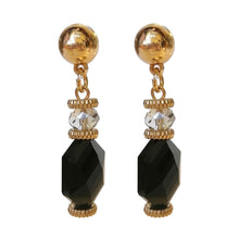 Load image into Gallery viewer, Zwarte statement oorbellen uit de Veerle Collectie! Deze oorbel is een echte eyecatcher. De oorbellen zijn gemaakt van geslepen kristal en zijn ook nog eens gold dipped. De oorbel is verkrijgbaar in verschillende kleuren: zwart, beige, paars, blauw. De afmeting van de oorbel is 4,7cm x 1cm.