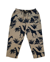 Load image into Gallery viewer, Linnen broek van Moment by Moment. De broek heeft wijde pijpen en een lengte van 7/8. De tailleband is van elastiek met een touwtje om de broek vast te strikken. Deze zandkleurige broek heeft een super mooie jungle print. Is als pak te dragen samen met dezelfde print top, maar kan ook gecombineerd worden met een zwarte of gekleurde top, blouse of trui.