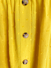 Afbeelding in Gallery-weergave laden, Gele Top Dobby heeft een kort mouwtje met een strikje, wat een leuk detail is. De top heeft een ronde hals, een rij knoopjes en heeft aan de onderzijde een elastische band met ruffles. Top kan zowel op de schouder als off-shoulder gedragen worden en is verkrijgbaar in verschillende kleuren. Kleur : Blauw, Geel, Wit