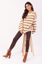 Afbeelding in Gallery-weergave laden, Camel Trui Gestreept, grof gebreide gestreepte trui, wijder model, met als leuk detail goudkleurige knopen op weerszijde schouders en de trui heeft een ronde hals. Deze trui is verkrijgbaar in verschillende kleuren: groen/ecru, camel/ecru, zwart/ecru.