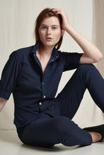 Afbeelding in Gallery-weergave laden, Donkerblauwe Blouse Lissy U7222550 van Jane Lushka is een getailleerde blouse in donkerblauw met kraag. Blouse heeft mooie naden en paspelzakken op de borst, drukknopen en korte mouwen met manchet en een knoop. Het model is aansluitend en loopt aan de onderkant rond. Combineer deze met Shorts Yana in dezelfde donkerblauwe kleur.