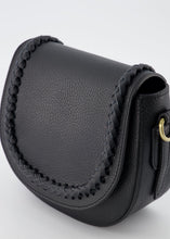 Afbeelding in Gallery-weergave laden, Zwarte Lederen tas Chelsea is een stevige halfronde klassieke tas met een gevlochten bies op de klep. Aan de binnenzijde zit een ritssluiting. De tas komt met een verstelbaar en afneembaar lang hengsel. Tas Chelsea is ook crossbody te dragen en is verkrijgbaar in verschillende kleuren: wit leer, zwart leer, terra leer, taupe, groen suède leer, okergeel suède leer. Ook ontzettend leuk om bij deze tas een losse 'bagstrap' met een mooie print te bestellen, dan kun je dezelfde tas op twee manieren dragen.