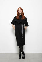 Load image into Gallery viewer, Zwarte Jurk, Dame Blanche Jurk Fem 983 Milan Black is een jurk met een opstaande kraag en heeft half lange mouwen. Jurk valt over de knie en heeft als leuk detail twee stansringen met een speels dessin ceintuur. Zeer zachte stof, draagt erg comfortabel!