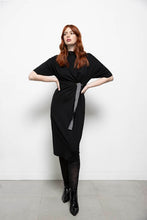 Load image into Gallery viewer, Zwarte Jurk, Dame Blanche Jurk Fem 983 Milan Black is een jurk met een opstaande kraag en heeft half lange mouwen. Jurk valt over de knie en heeft als leuk detail twee stansringen met een speels dessin ceintuur. Zeer zachte stof, draagt erg comfortabel!