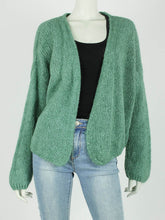 Afbeelding in Gallery-weergave laden, Groen Vest Suze is een royaal vallend grof gebreid vest met stoer uiterlijk en heeft franjes op het achterpand. Vest Suze is verkrijgbaar in verschillende kleuren: Emerald, Licht Beige, Zwart, one size en draagbaar t/m maat 42.