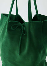 Afbeelding in Gallery-weergave laden, Groene Lederen suède schoudertas Mia is een soepel vallende shopper met knoopsluiting en heeft aan de binnenkant van de tas een extra tasje met ritssluiting. Deze schoudertas is verkrijgbaar in verschillende kleuren: Kelly Green suède, Groen suède, Bruin suède, Cheetah suède, Terra, Ecru. Deze lederen suède shopper handtas is waterproof behandeld, maar wees voorzichtig met water. Afmeting tas is 40cm x 13cm x 35cm.