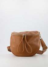 Afbeelding in Gallery-weergave laden, Lederen Crossbody Tas, Romsa in de kleur Cognac is gemaakt van Italiaans leer. De tas bestaat uit een hoofdvak en is te sluiten door middel van een rits. In het hoofdvak zit een afsluitbaar steekvak. De tas heeft een afneembaar en verstelbaar hengsel van leer met een canvas rand. De tas kan als crossbody tas gedragen worden, maar ook als heuptas. En is verkrijgbaar in verschillende kleuren: Ecru, Navy, Zand suede, Cognac. Afmeting tas : 30cm x 26cm x 13cm