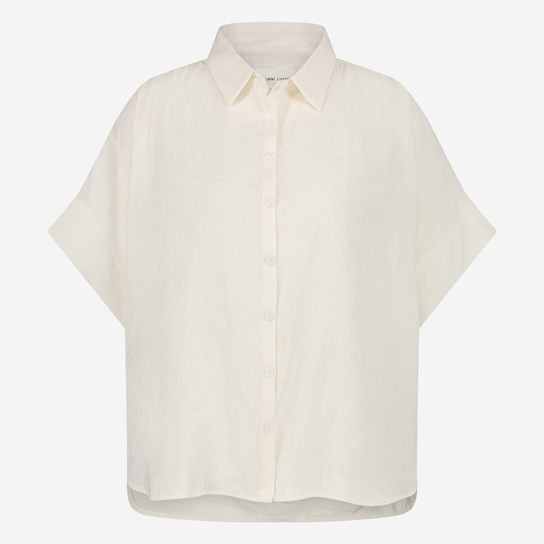 Off White Blouse van de Jane Lushka Collectie. Romi Blouse is een vrouwelijke blouse met kraag, knoopjes en heeft een lage mouwinzet. Deze elegante blouse is vrouwelijk en tijdloos en is vervaardigd van een glad materiaal en heeft een chique uitstraling.